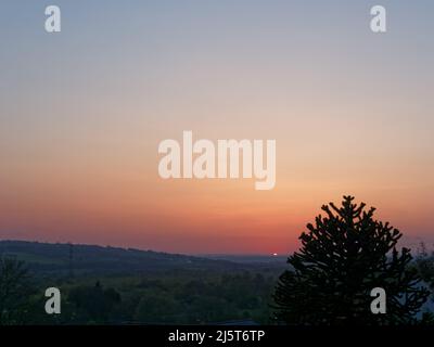 Silhouetted trees against a sunset over Horbury Bridge in Wakefield, West Yorkshire. Stock Photo