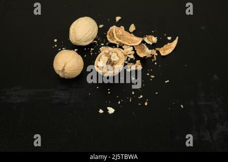 Three walnuts on a dark scratched background Stock Photo