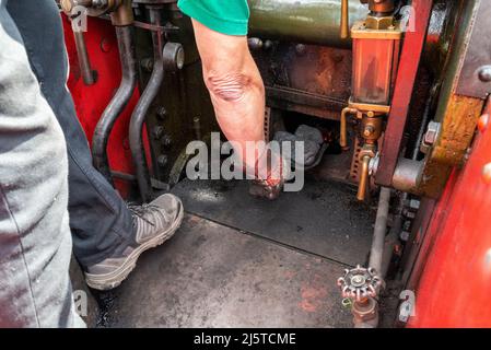 Coal being shovelled into the firebox of a steam traction engine. Welsh dry steam coal on shovel in hand of driver of a Burrell road traction engine Stock Photo
