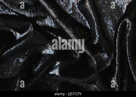 Closeup of tousled shiny black silk fabric closeup Stock Photo