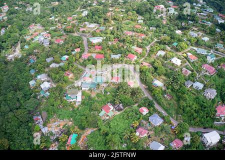 Aerial view of roadway winding through island houses among urban green nature in Mahe, Seychelles. Stock Photo