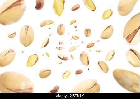 Collection of pistachio nuts falling isolated on white background. Selective focus Stock Photo