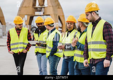 Multiracial people working at industrial construction site outdoor - Soft focus on african senior woman face Stock Photo