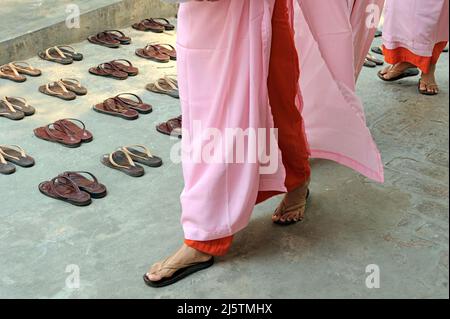 Buddhist nuns removing sandals before entering the dining hall at the Sakyadhita Thilashin Nunnery School in Sagaing, Myanmar Stock Photo