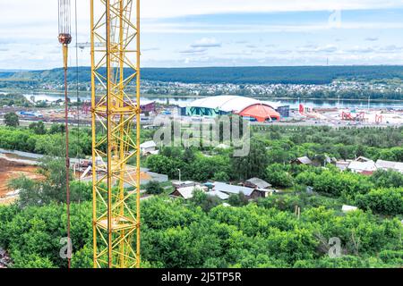 a tower crane against the background of the area being built up symbolizes the displacement of private property by public buildings, selective focus Stock Photo