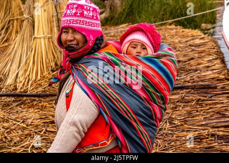 An Uros Mother and Child On The Uros Floating Islands, Lake Titicaca, Puno, Peru. Stock Photo