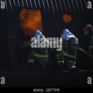 A team of firefighters enter a training aircraft during the joint firefighter integrated readiness ensemble training exercise on Vandenberg Space Force Base, Calif., April 7, 2022. The Vandenberg Fire Department trains on JFIRE annually to retain their certification. (U.S. Space Force photo by Airman 1st Class Ryan Quijas) Stock Photo