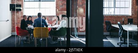 Team of businesspeople having a discussion during a meeting. Group of creative businesspeople attending their morning briefing in an office. businessp Stock Photo