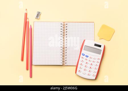 Notebook with colorful pencils and calculator on color background Stock Photo