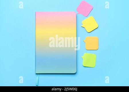 Notebook and sticky note papers on color background Stock Photo