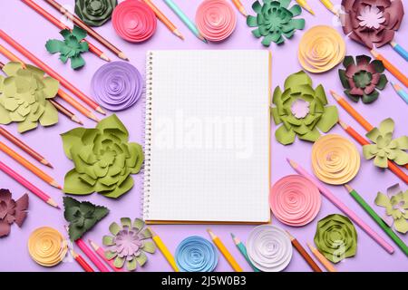 Composition with blank notebook, paper flowers and colorful pencils on color background Stock Photo