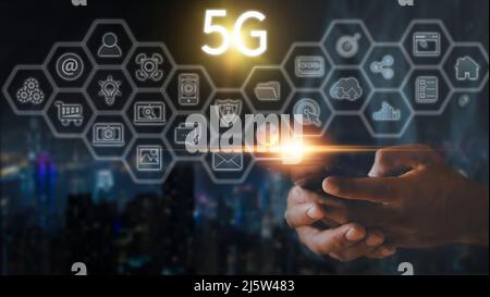Hand of business man hold mobilephone connect network 5G with icon concept, technology network wireless systems and internet of things, new technologi Stock Photo