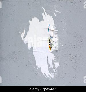 shabby gray concrete wall with torn paper placard. abstract background. Stock Photo