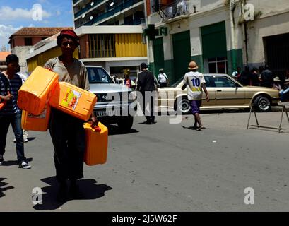 A Malagasy man carrying jerrycans at the market in Antananarivo, Madagascar. Stock Photo