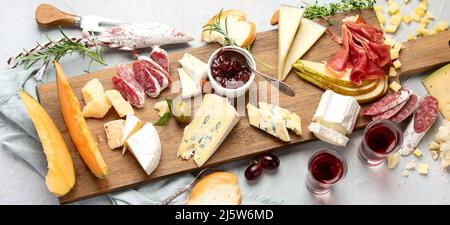 Cheese assortment on light background. Gourmet appetizers on tray. Italian food concept. Top view, flat lay, panorama Stock Photo