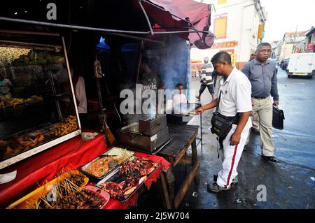 A Malagasy man grilling skewers at a small restaurant in central Antananarivo, Madagascar. Stock Photo