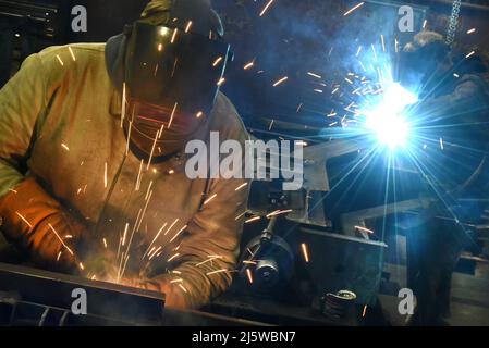 25 April 2022, Saxony-Anhalt, Dessau-Roßlau: At Roßlauer Schiffswerft GmbH & Co.KG, welders are working on Y-sleepers for rail lines operated by Deutsche Bahn and customers in other European countries. The company has a very good order situation for the next months. Bridge parts weighing several tons are currently being manufactured for the Tegel Bridge over the Spandau Ship Canal in Berlin. The bridge project is among a further 20 bridges, installations for locks and flood protection that will leave the company by mid-2023. Around 2,000 tons of steel are processed annually at the shipyard, Stock Photo