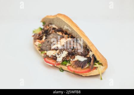 shawarma or doner with yogurt , tomatoes and herbs in a bun. Stock Photo