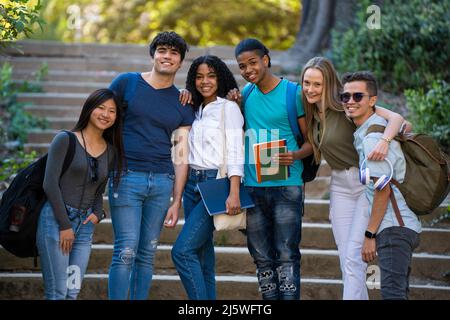 Group of young multiracial students waving at the camera on some stairs Stock Photo