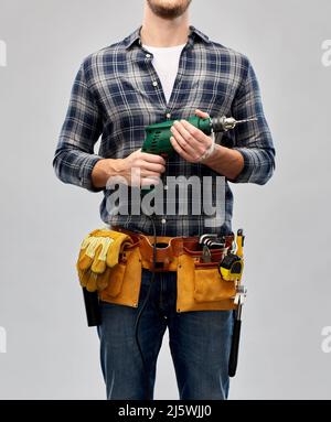 male repairer or builder with drill and work tools Stock Photo