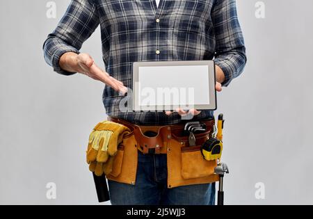 male builder with working tools showing tablet pc Stock Photo