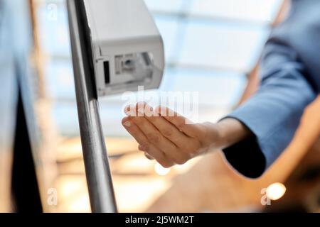 close up of woman at dispenser with hand sanitizer Stock Photo