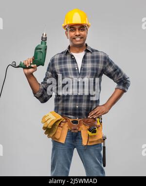 happy indian builder in helmet with electric drill Stock Photo