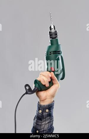 close up of builder's hand holding drill Stock Photo