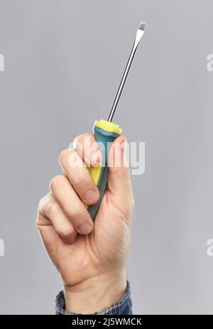 close up of builder's hand holding screwdriver Stock Photo