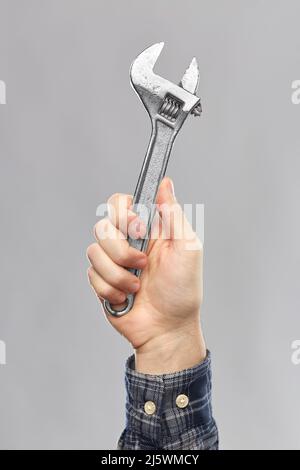 close up of builder's hand holding wrench Stock Photo