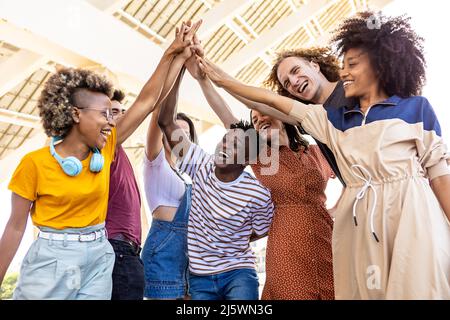 Group of united multiracial people stacking hands together ...