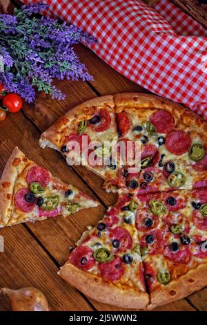 pizza in a pizzeria with salami and vegetables Stock Photo