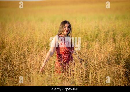 Girl dressed as a communion in the field, between trees and paths Stock Photo