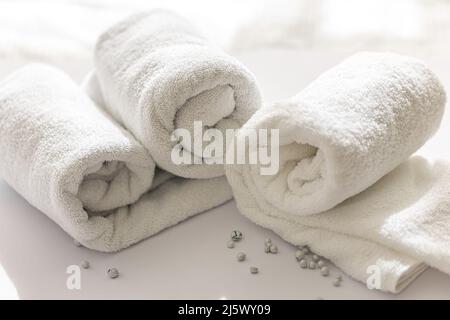 Close-up of a rolled white bath towels on a white background. Stock Photo
