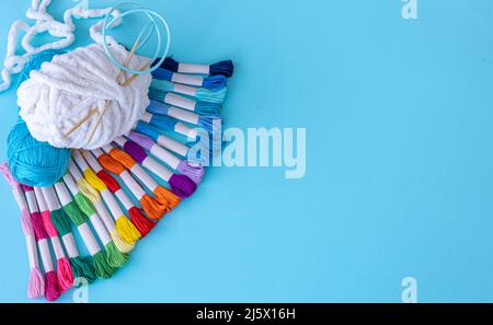 Threads of different colors on a blue background. Stock Photo