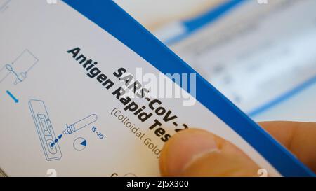 Close up of man examines box with Sars-Cov-2 antigen rapid test with instruction Stock Photo