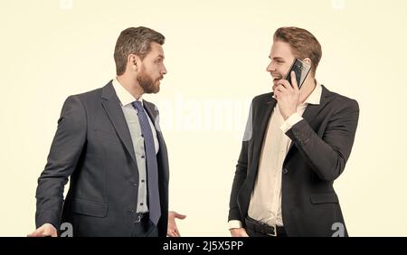 angry boss arguing with smiling employee speaking on phone isolated on white, conflict Stock Photo
