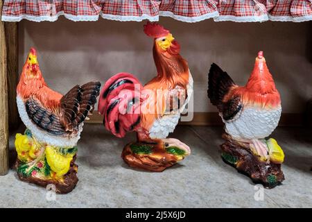 Three large colorful ceramic sculptures of roosters standing on floor in souvenir shop. Stock Photo