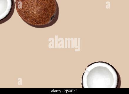 Full and halved coconuts on beige background Stock Photo