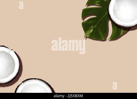 Coconuts and monstera leaf on beige backdrop Stock Photo