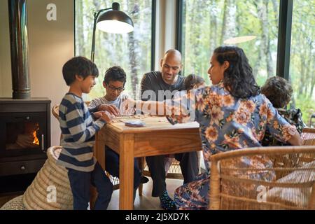 Family playing scrabble at dining table Stock Photo