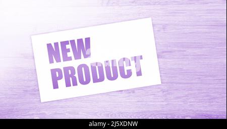 New Product words on card on wooden table. Business concept. Stock Photo