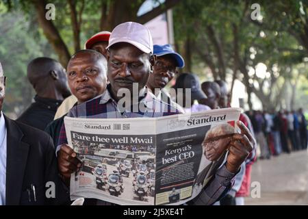 Nairobi, Kenya. 25th Apr, 2022. A member of the public reads a newspaper reporting on the death of the former president of Kenya Mwai Kibaki as he queues to see his body which is lying in state for the second day at the Parliament Building. The former head of state, who ruled for eight years (December 2002 until April 2013) died on April 22, 2022, as announced by the current president Uhuru Kenyatta. Credit: SOPA Images Limited/Alamy Live News Stock Photo