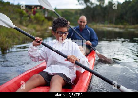 Father and son kayaking on river Stock Photo