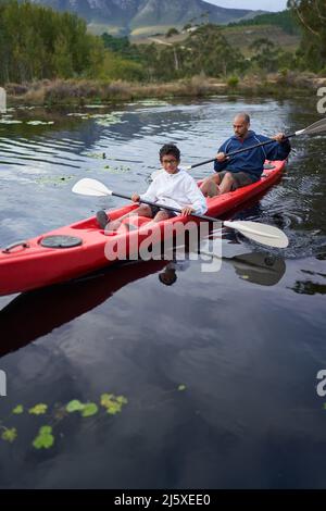 Father and son kayaking on river Stock Photo