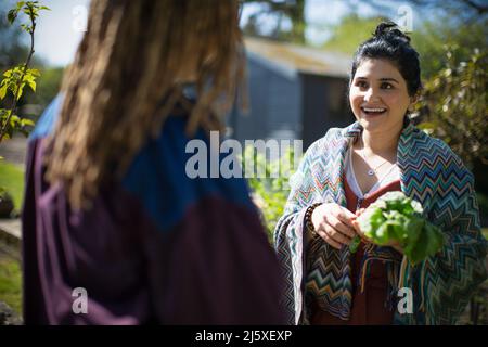 Happy young women talking in garden Stock Photo