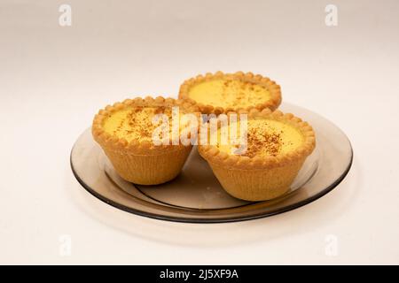 Three home made Egg Custard Tart on plate isolated on white Stock Photo