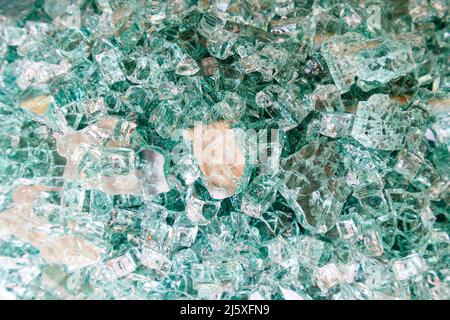 Surface full of broken tempered glass shards, broken green tempered glass. Stock Photo