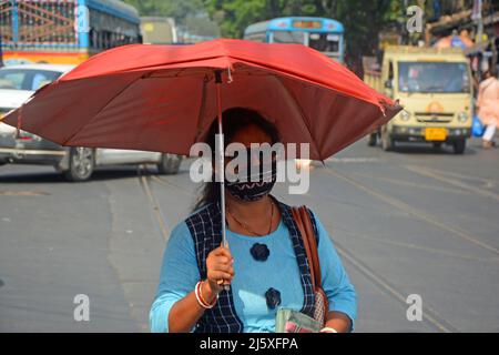Kolkata, India. 26th Apr, 2022. A woman came outside holding an umbrella in a hot summer day.Today's temperature in Kolkata is around 40°c. The Met office declared a heatwave alert for most districts in South Bengal till 28th April.But it will continue to be warm and uncomfortable with no chance of rain, according to the Regional Meteorological Centre (RMC) till April 28. (Photo by Rahul Sadhukhan/Pacific Press) Credit: Pacific Press Media Production Corp./Alamy Live News Stock Photo