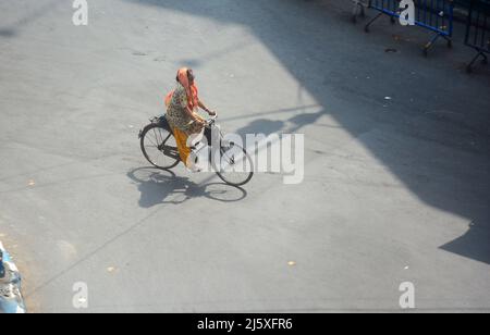 Kolkata, India. 26th Apr, 2022. A woman was cycling in a hot summer day.Today's temperature in Kolkata is around 40°c. The Met office declared a heatwave alert for most districts in South Bengal till 28th April.But it will continue to be warm and uncomfortable with no chance of rain, according to the Regional Meteorological Centre (RMC) till April 28. (Photo by Rahul Sadhukhan/Pacific Press) Credit: Pacific Press Media Production Corp./Alamy Live News Stock Photo